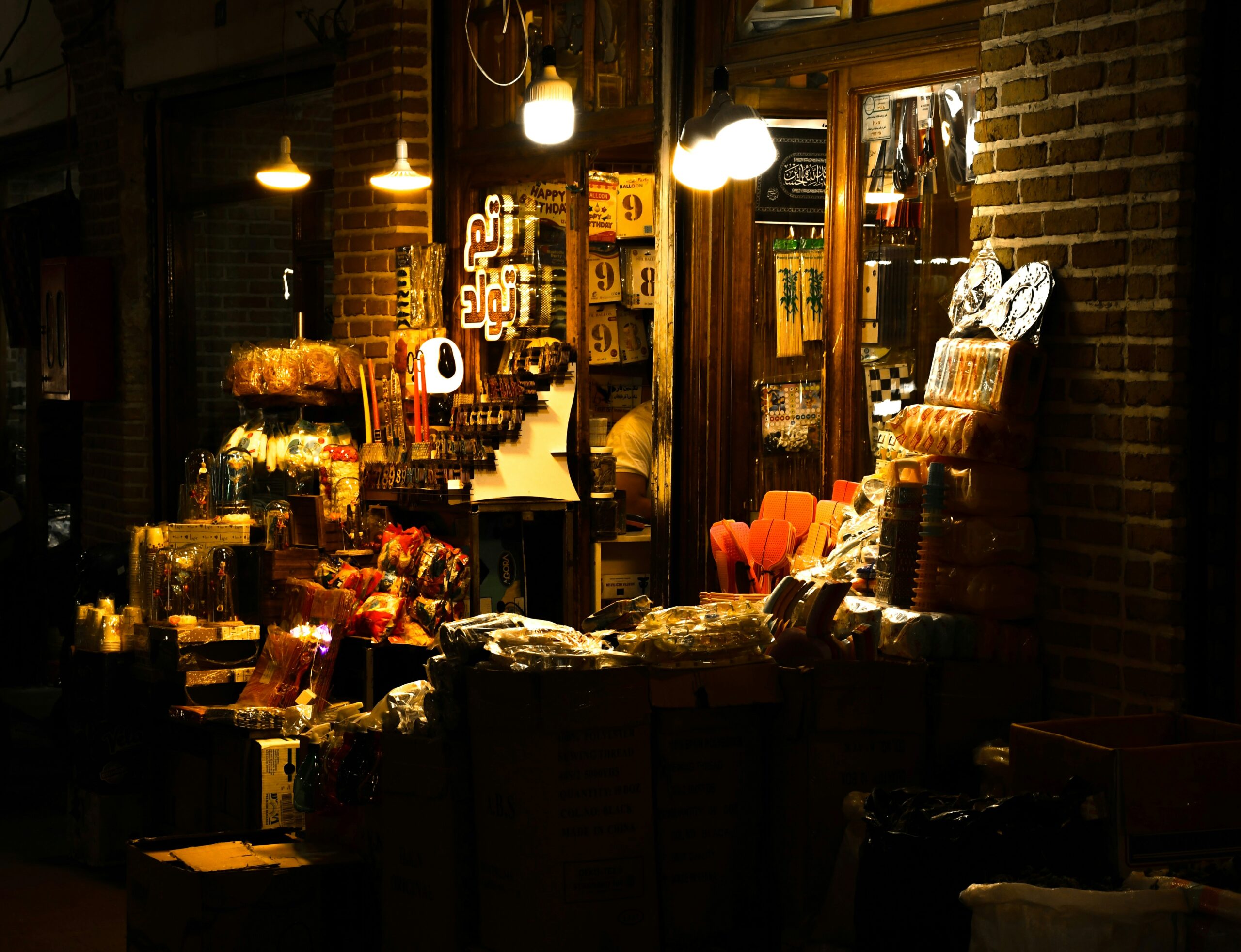 A store front at night filled with lots of items